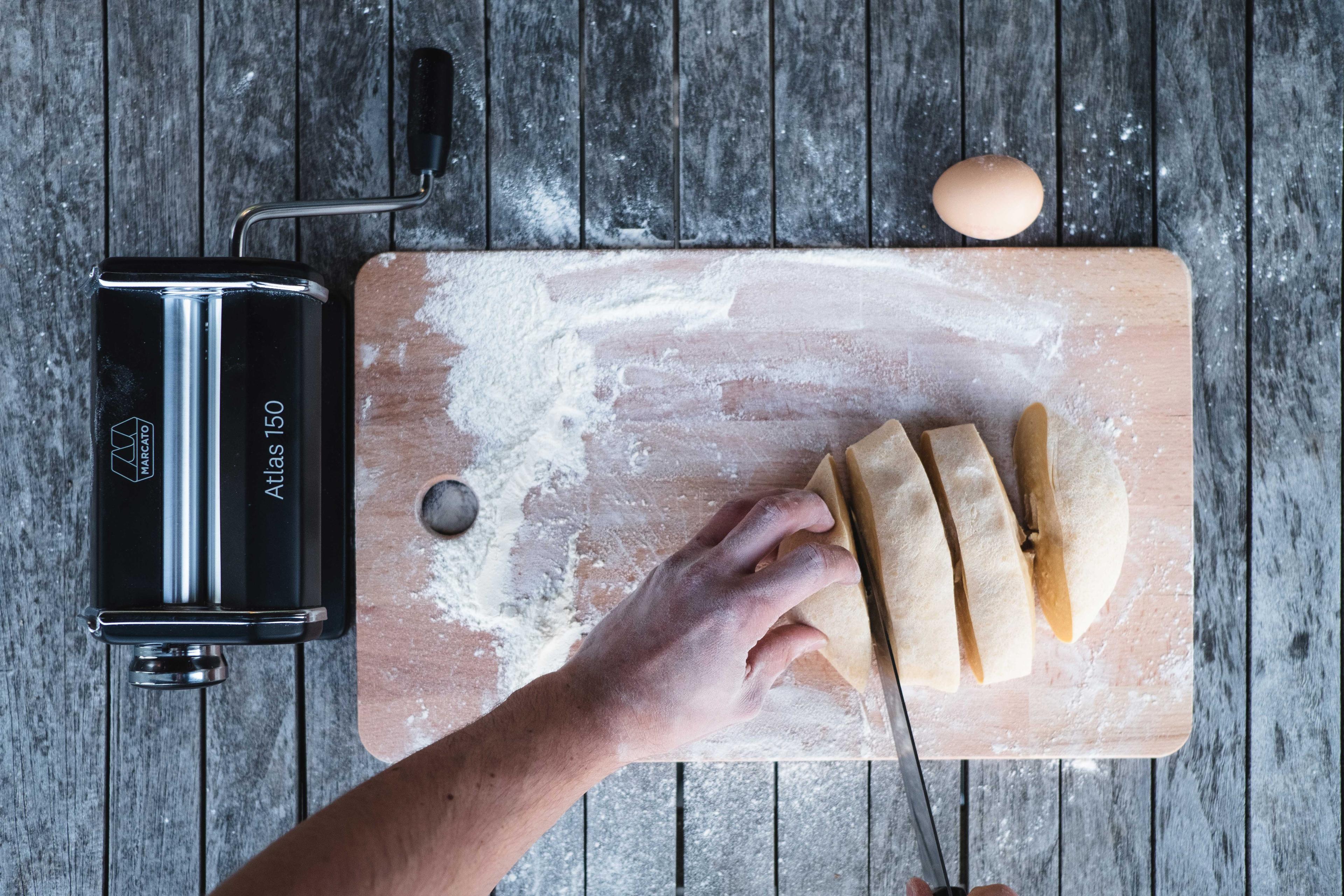 Teig portionieren, daneben die Nudelmaschine