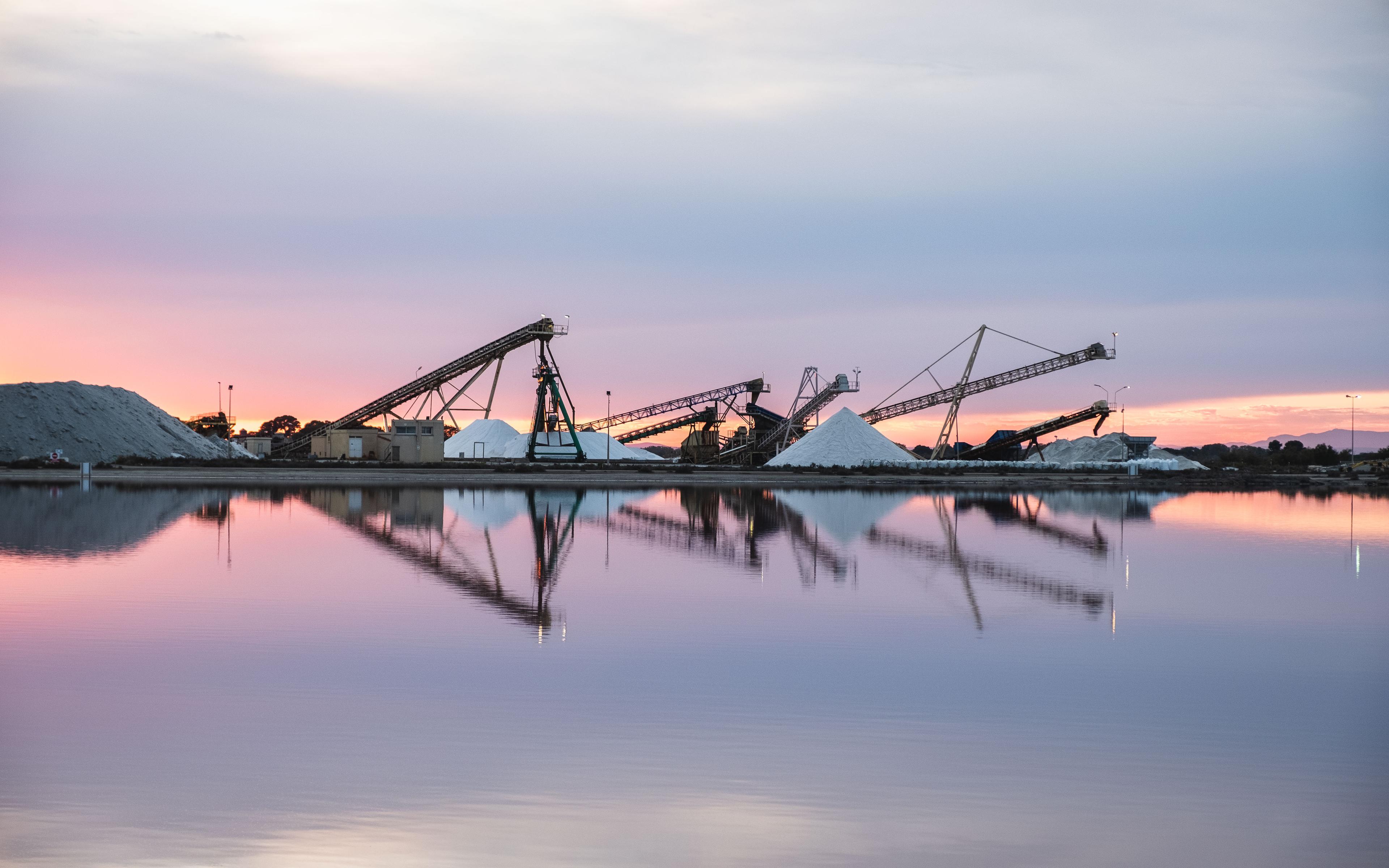 Die Salin du Midi liegen vor den Toren von __Aigues-Mortes__, einer kleinen mittelalterlichen Festungsstadt im Westen der Camargue. Im 13. Jahrhundert besaß die Stadt einen bedeutenden Mittelmeerhafen. Doch der Hafen verlandete zunehmend, so dass der Seehandel schon im 14. Jahrhundert von der Salzgewinnung als wichtigste Wirtschaftsaktivität abgelöst wurde. Ihre beeindruckende und gut erhaltene Stadtmauer und ihre gemütliche Altstadt machen sie heute zu einem beliebten Tourismuszentrum.